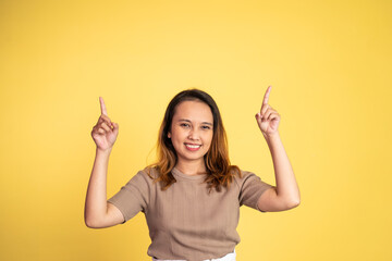 attractive asian woman with finger pointing up hand gesture on isolated background