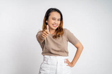 attractive smiling young woman stand with thumbs up on isolated background
