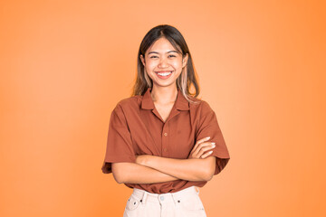 young beautiful ethnic asian woman stand with crossed hands on isolated background