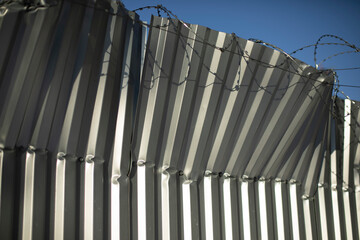 Obraz premium Broken fence. Fence from profile sheet bent. Rumpled iron.