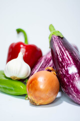 Closeup shot of vegetables like onion, pepper, eggplant over a white background