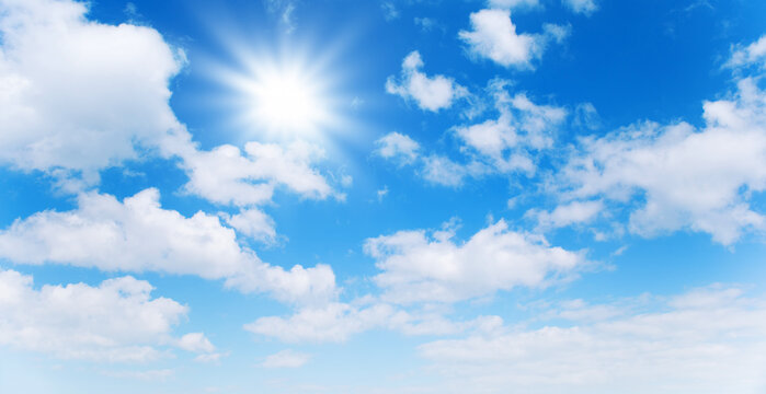 Sunny day background, blue sky with white cumulus clouds and sun