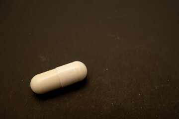 white capsule for patient on black paper. Prescription opioid oval pills. Opioid crisis. Medical white capsules isolated on a black background. Capsules for treatment