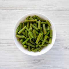 Steamed Green Beans in a White Bowl, top view. Overhead, from above, flat lay.