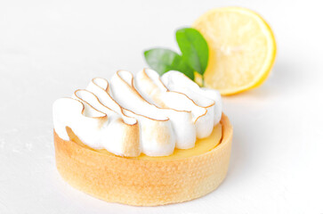 Lemon tart with white cream on white background. Front view