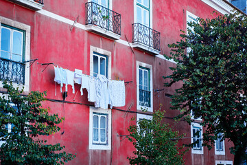 Fototapeta na wymiar Travel by Lisbon. Ancient architecture of old town. Drying clothes.