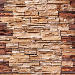 Brick wall cladding with narrow natural stones of various sizes and shapes.