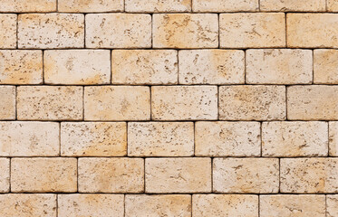 Fototapeta premium Brick wall, natural yellowish limestone stone. A specially prepared pattern for a seamless fill.