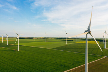 Wind Turbines Windmill Energy Farm. Wind turbines on sunny morning. Windmills wind turbines farm power generators against landscape against blue sky in beautiful nature. Aerial. 