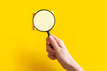 Magnifying glass in hands. Stickers under magnification