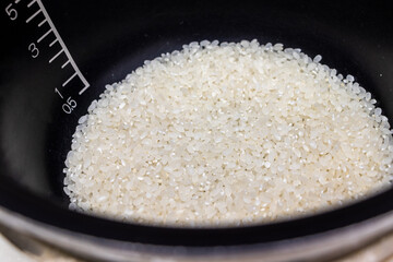 炊飯器の黒い釜の中に白い生米