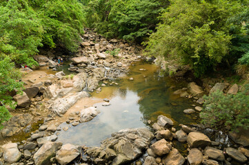 Wild tropical jungle creek with large boulders