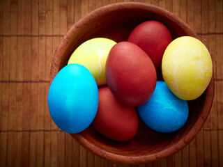 Fototapeta na wymiar Multi-colored Easter eggs in a wooden bowl.