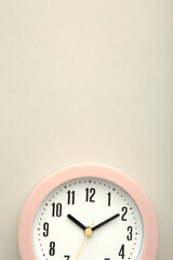 Pink clock on grey background. Top view. Vertical photo