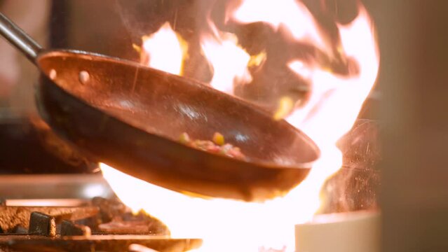 Fiery flambe in a skillet, capturing the art of cooking in a rustic kitchen at dusk