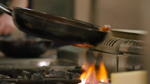 Fiery flambe in a skillet, capturing the art of cooking in a rustic kitchen at dusk