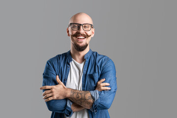 Portrait of young bald bearded man in glasses who wearing casual clothes very happy smiling