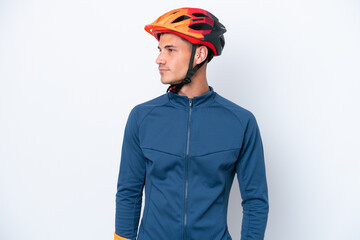 Young cyclist caucasian man isolated on white background looking to the side