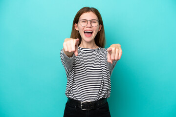 Young English woman isolated on blue background surprised and pointing front