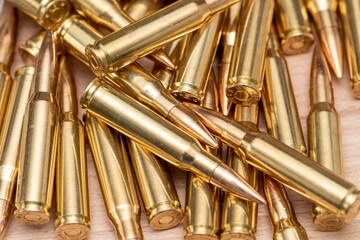 A scattering of cartridges with 7.62 caliber bullets for the Kalashnikov assault rifle, close-up, selective focusing. Concept: sale of weapons under lend-lease, assistance with ammunition, supply of w