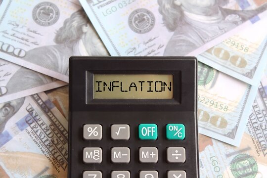 Close up image of banknotes and calculator with text INFLATION. Business and financial concept.