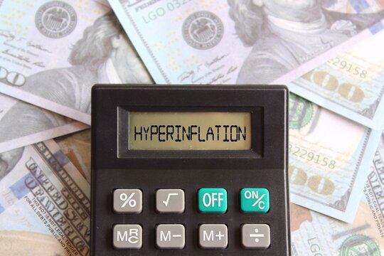 Close up image of banknotes and calculator with text HYPERINFLATION. Business and financial concept.