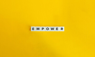 Empower Word on Letter Tiles on Yellow Background. Minimal Aesthetics.