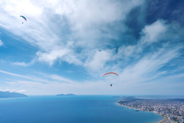 Athlete paragliding against the backdrop of a cloudy sky over the city on a summer day. Albania