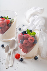 Tasty and homemade Panna Cotta with raspberries and blueberries.