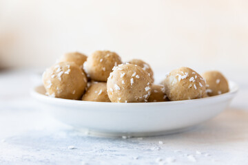 Chickpea and peanut butter candies with coconut chips. Energy balls. Healthy raw dessert without sugar. Vegan truffles.