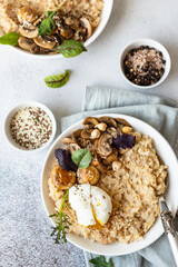 Savory porridge for breakfast. Oatmeal or spelt flakes with poached egg, fried mushrooms and herbs. Healthy food. Keto diet.