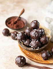 Vegan chickpea and peanut butter candies in chocolate glaze with coconut chips. Energy balls. Healthy raw dessert without sugar.