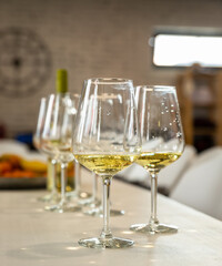Different types of glasses for wine on table. Wine glasses with white wine and empty. Still life concept. Blurred background.