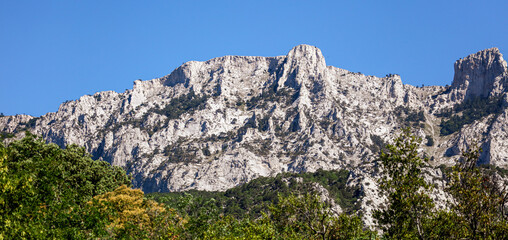 Peaks of rocky mountains against a blue sky.