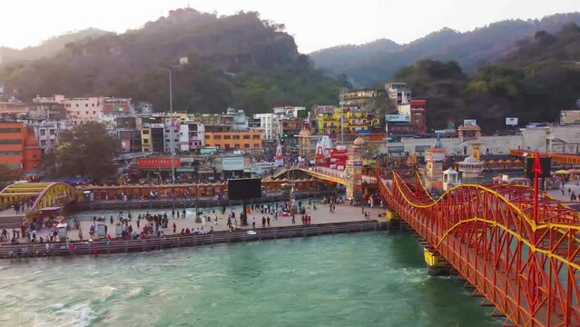isolated iron bridge many over ganges river with wide view of city at riverbank at evening