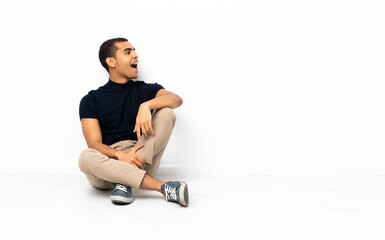 African American man sitting on the floor laughing in lateral position