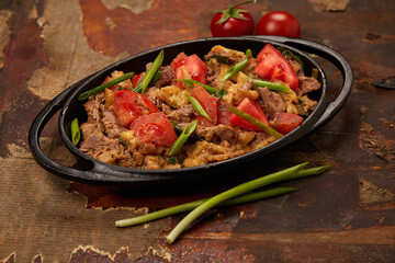 Fired meat spiced with greens and tomatos
