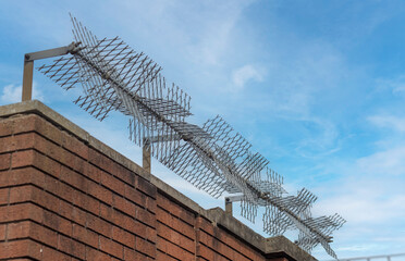 anti climb fencing on top of a high brick wall for security