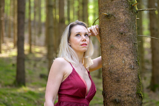 Attractive woman in sexy dress contemplating at forest.