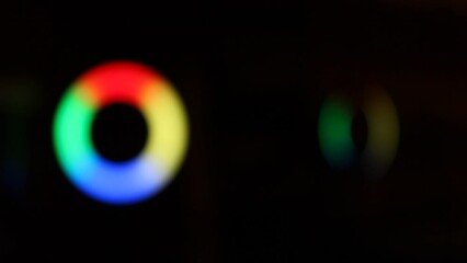 A rotating blurred light ring of four sectors or segments of blue, green, yellow and red color. Progress indicator. Background illumination. LED lamp effect. - Powered by Adobe