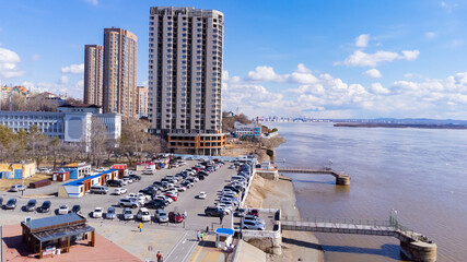 City embankment on the Amur River in Khabarovsk in early spring. A sunny day. The ice on the river...