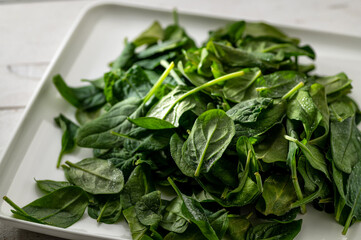 Frozen spinach, on a light background, green leaves with frost