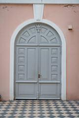 Gray wooden door of a pink house.