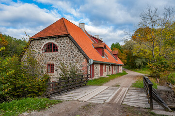 Fototapeta na wymiar Landscape with an old watermill. Picturesque empty country road leading to an old mill in rural area. Estonia. Baltic.
