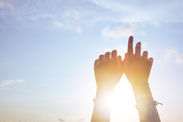 Woman hands against blue sky and sun