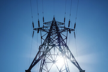 Electrical transmision high-voltage tower on blue sky background.