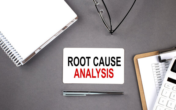 ROOT CAUSE ANALYSIS text written on the card with notebook and clipboard, grey background