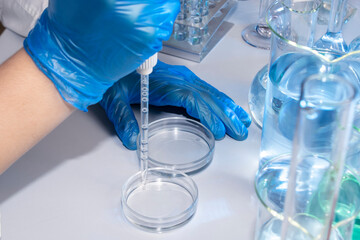 Hand of a scientist taking samples with a pipette