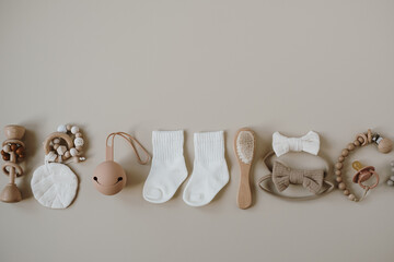 Cute hygge pastel accessories for newborn baby care. Brush, pacifier, socks, bow, pacifier holder on pastel pale beige background. Aesthetic newborn baby fashion store, shopping collage