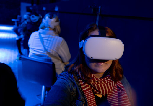 Fototapeta Adult woman using virtual reality goggles in sensory environment.
